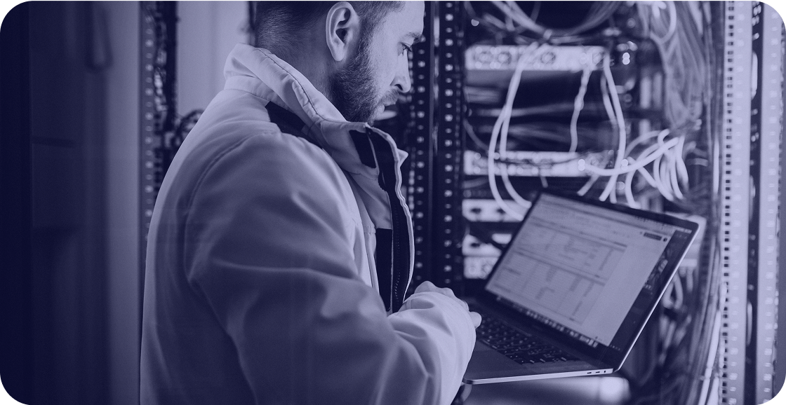 Persona trabajando en configuración de red en sala de servidores